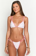 model wearing a white triangle bikini top with red florals and a red gingham trim paired with matching swim bottoms