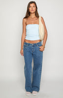 girl wearing low rise mid wash denim jeans paired with black sandals