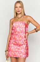 Girl wearing a vibrant orange floral print mini dress with pink and yellow blooms, a sleek strapless neckline and a smooth, figure-accentuating silhouette