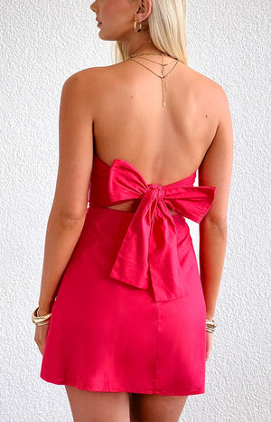 Girl wearing a red strapless mini dress with an adjustable tie back detail paired with gold jewellery