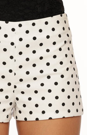 Close-up of the white shorts with black polka dots, showing the neat hem and waistband